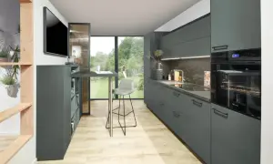 Cocinas modernas con armarios grises, encimera de piedra y suelo de madera clara. Un taburete alto gris junto a una barra.