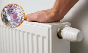 Un radiador blanco con un termostato y un círculo de billetes de 500 euros. Es bueno apagar la caldera por la noche para ahorrar dinero.