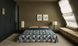 Dormitorios pequeños con cama geométrica, lámparas de diseño y un banco tapizado junto a la ventana.