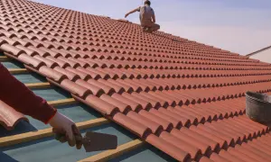 Instalación de tejas rojas, mostrando diferentes tipos de cubiertas en proceso. Un trabajador coloca tejas, otro supervisa.