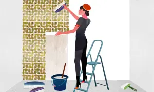 Una mujer con boina naranja aplica papel pintado con un cepillo. Muestra cómo poner papel pintado en una pared con un patrón de hojas y bayas.