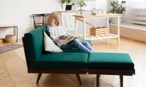 Mujer lee en un sofá modular verde, un ejemplo de muebles que se transforman para adaptarse a tu espacio y estilo de vida.