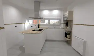 Cocinas con península modernas, blancas y de madera, con encimera de madera, campana extractora y estanterías.