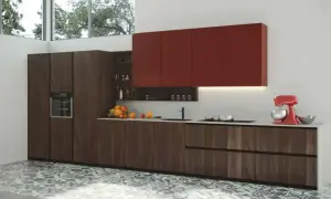 Modernos diseños de cocinas con gabinetes de madera oscura, encimeras blancas y gabinetes superiores rojos vibrantes. Una batidora roja y frutas añaden color.