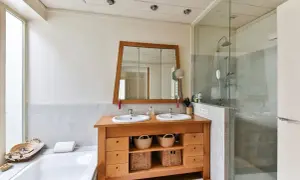 Baño moderno con doble lavabo y ducha acristalada. La limpieza mampara ducha es clave para mantener este espacio impecable.
