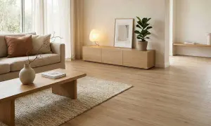 Salón con sofá beige, mesa de centro de madera y alfombra de yute. La decoración japandi se realza con una lámpara de papel y una planta.