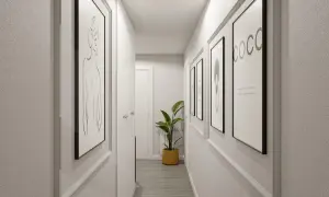 Pasillos decorados con arte minimalista y una planta verde, creando un ambiente moderno y acogedor.