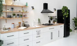 Cocina blanca y moderna con encimera de madera, campana negra y nevera retro. ¡Ideas para modernizar cocina sin obras!