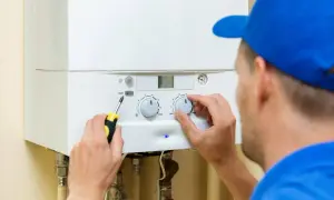 Técnico ajustando la caldera de gas. Encender y apagar la caldera de gas frecuentemente es malo para su vida útil.
