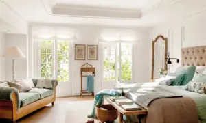 Ideas dormitorio matrimonio: cama con cabecero tapizado, sofá verde, espejo de cuerpo entero y ventanas con luz natural.