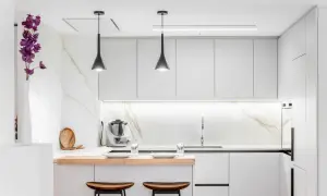 Cocina moderna y funcional, ideal para reformas de cocinas pequeñas. Muebles blancos, encimera de madera y detalles en mármol.
