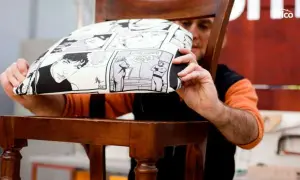 Hombre mostrando cómo tapizar una silla con tela de cómic.
