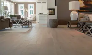 Amplio salón con chimenea y muebles elegantes, destacando los diversos tipos de parquet de madera clara que cubren el suelo.