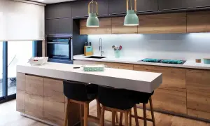 Cocina moderna con isla y taburetes. Ideas cocinas pequeñas: gabinetes de madera, encimera blanca y detalles en verde menta.