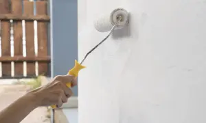 Mano aplica imprimación pintura pared con rodillo.