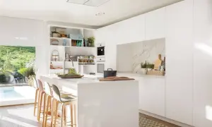 Cocina moderna y luminosa con isla central, taburetes y estanterías. Ideas de diseño cocina minimalista y funcional.