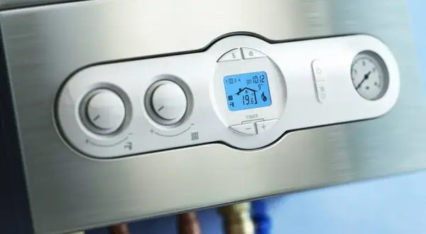 Panel de control de una caldera bomba de calor, con pantalla digital mostrando la temperatura y mandos giratorios.
