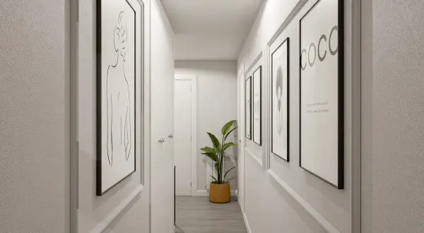 Pasillos decorados con arte minimalista y una planta verde, creando un ambiente moderno y acogedor.