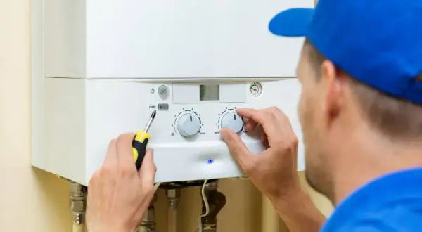 Técnico ajustando la caldera de gas. Encender y apagar la caldera de gas frecuentemente es malo para su vida útil.