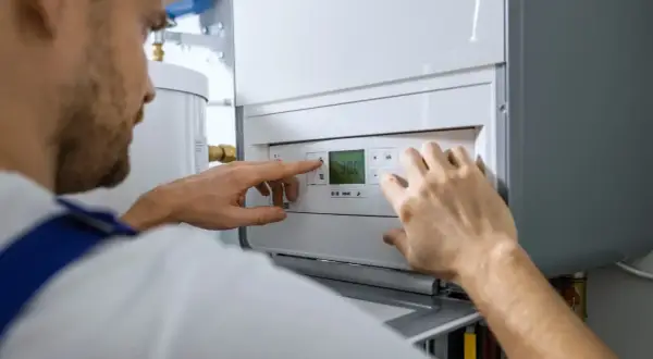 Técnico ajustando la temperatura en una caldera de gas nueva.