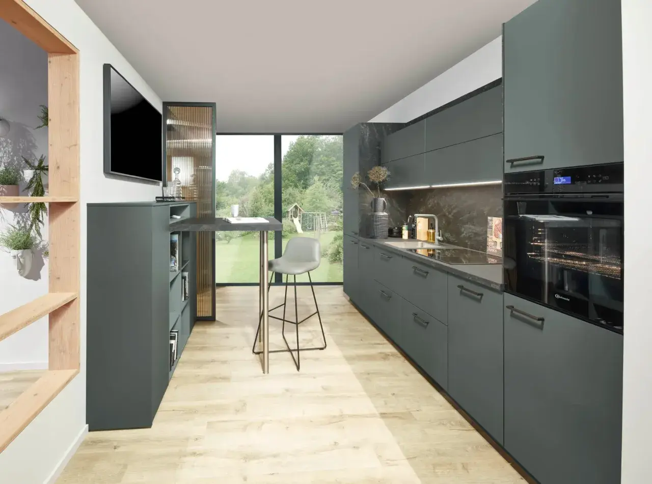 Cocinas modernas con armarios grises, encimera de piedra y suelo de madera clara. Un taburete alto gris junto a una barra.