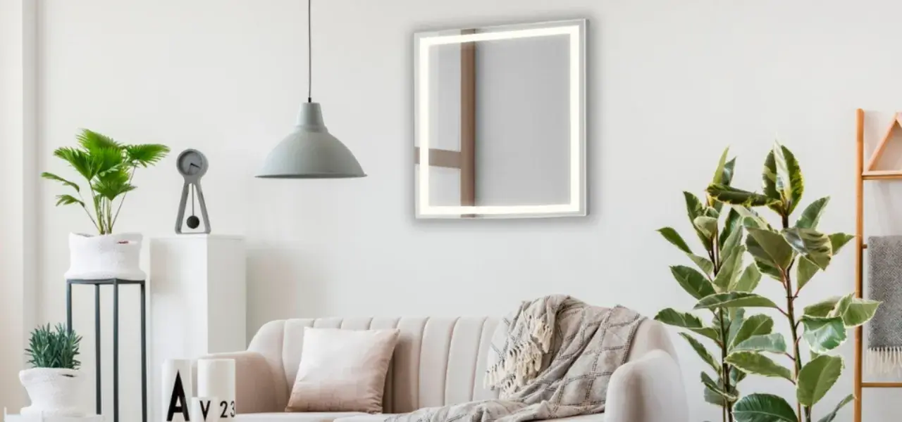 Un espejo iluminado sobre un sofá beige, con plantas y un reloj. Ideas de donde colocar espejos en el salón para ampliar el espacio.