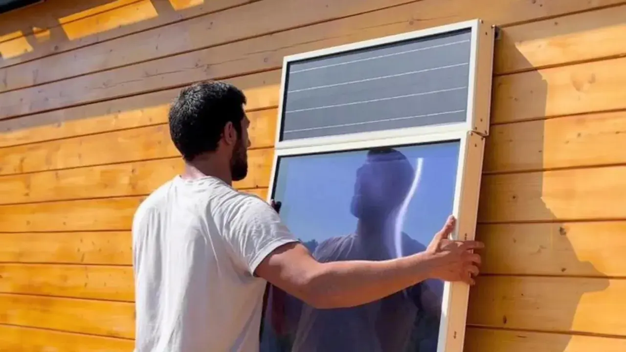 Hombre instala panel solar para calefacción en pared de madera.