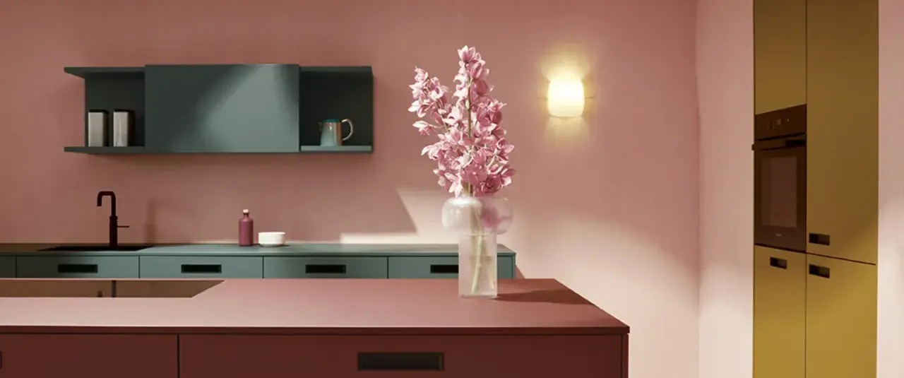 Elegante cocina con encimeras y armarios en tonos rosados y verde azulado. Un jarrón con flores rosas ilumina el espacio, creando una hermosa **combinación de colores para cocina**.