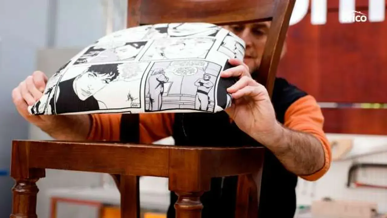 Hombre mostrando cómo tapizar una silla con tela de cómic.