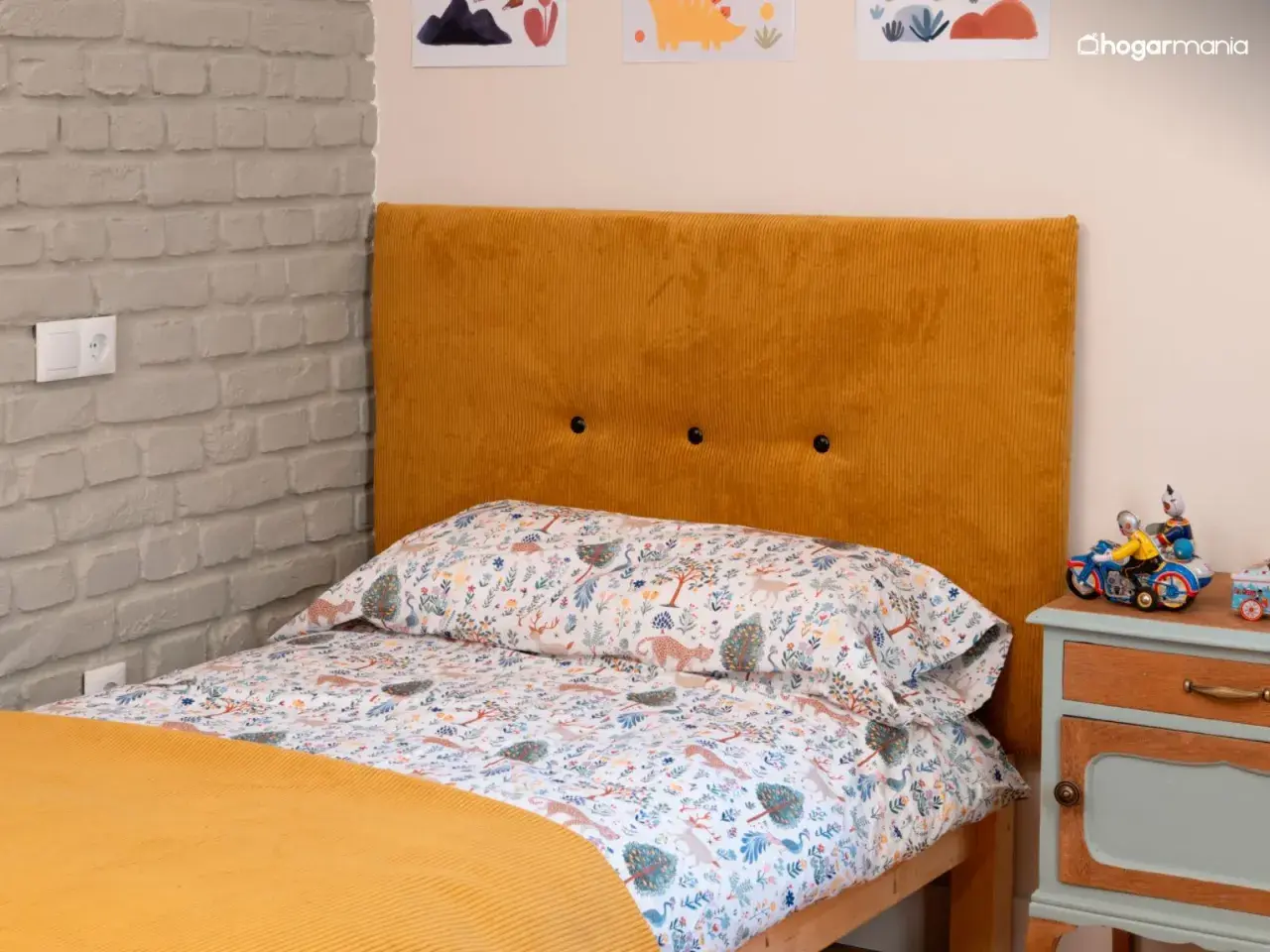 Cabecero tapizado en pana mostaza, ideal para aprender como tapizar un cabecero. Cama con ropa de cama infantil y mesita de noche.