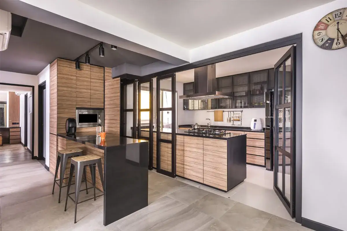 Moderna cocina semiabierta cristal con isla central, gabinetes de madera y barra de desayuno.