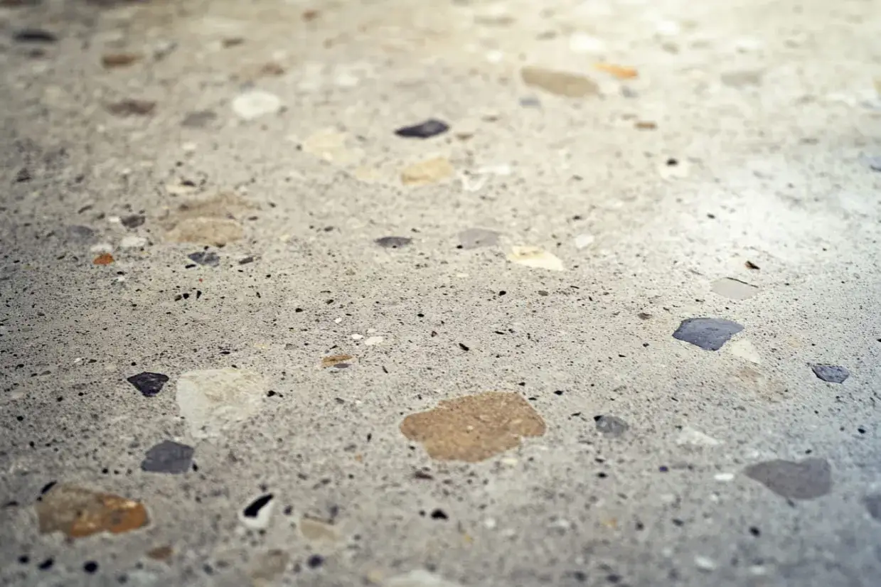 Detalle de un suelo de terrazo con fragmentos de piedra. Aprende como limpiar suelo de terrazo para mantenerlo impecable.