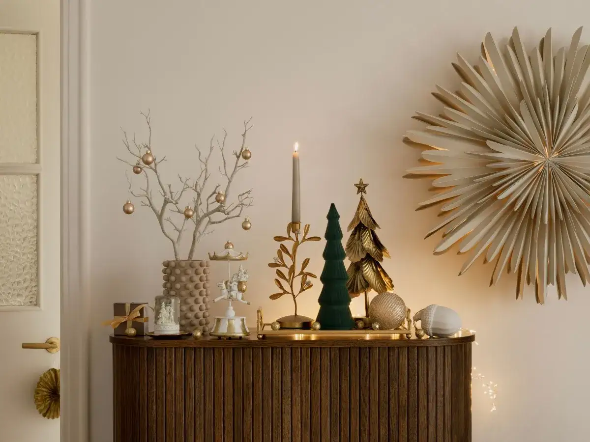 Decorar recibidor navidad con árbol seco adornado, cascanueces, mini árboles y estrella dorada.