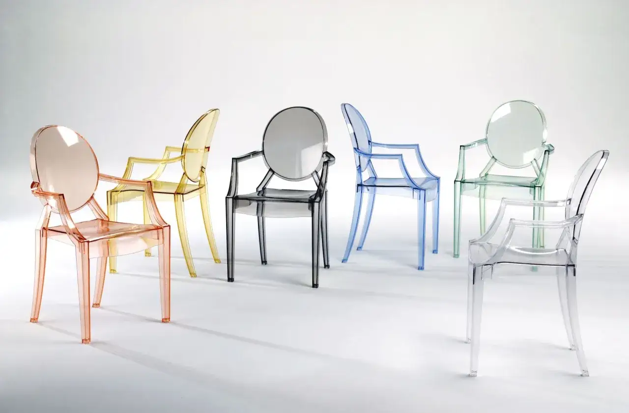 Seis butacas de diseño famosas transparentes en tonos rosa, amarillo, gris, azul, verde y transparente, dispuestas sobre fondo blanco.