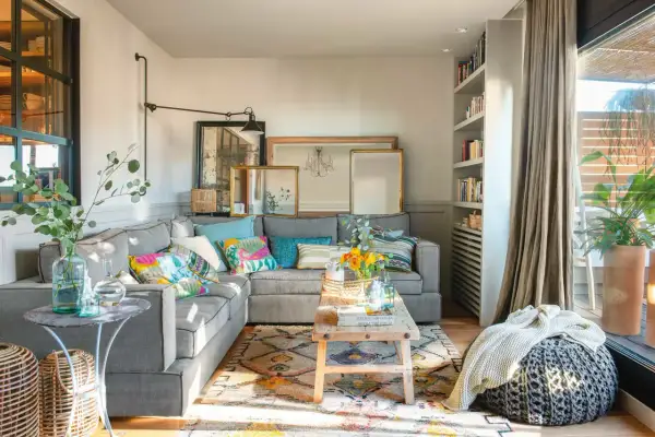 Acogedor salón con sofá gris, cojines coloridos y alfombra étnica. Un espacio que demuestra que las sencillas salas pequeñas pueden ser muy estilosas.