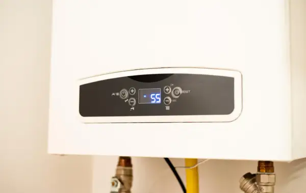 Panel digital de caldera de gas con temperatura a 55°C. Guía para saber como encender una caldera de gas antigua.