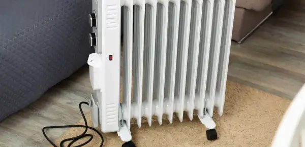 Radiador de aceite blanco con ruedas, mostrando cómo funciona un radiador de aceite al calentar la habitación.