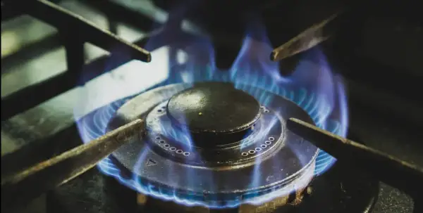 Llama azul arde en quemador de cocina, símbolo de la vida útil de una caldera de gas.