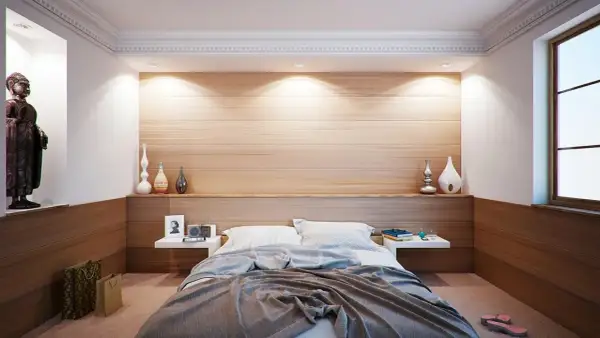 Ideas para distribuir un dormitorio de matrimonio: cama central, mesitas flotantes, nicho con Buda y decoración minimalista.